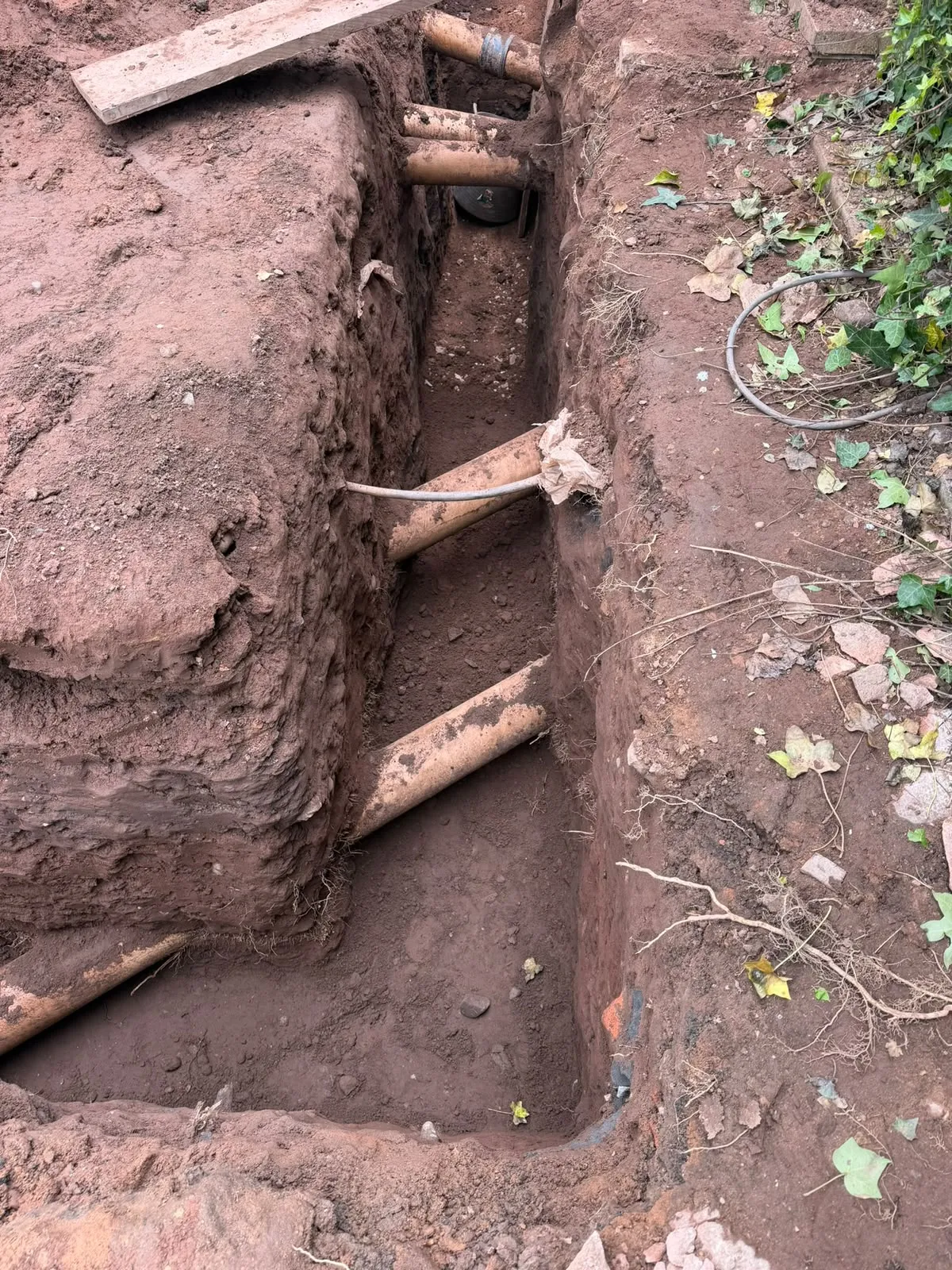 Concrete lintel bridging the exposed drains in the footing trench