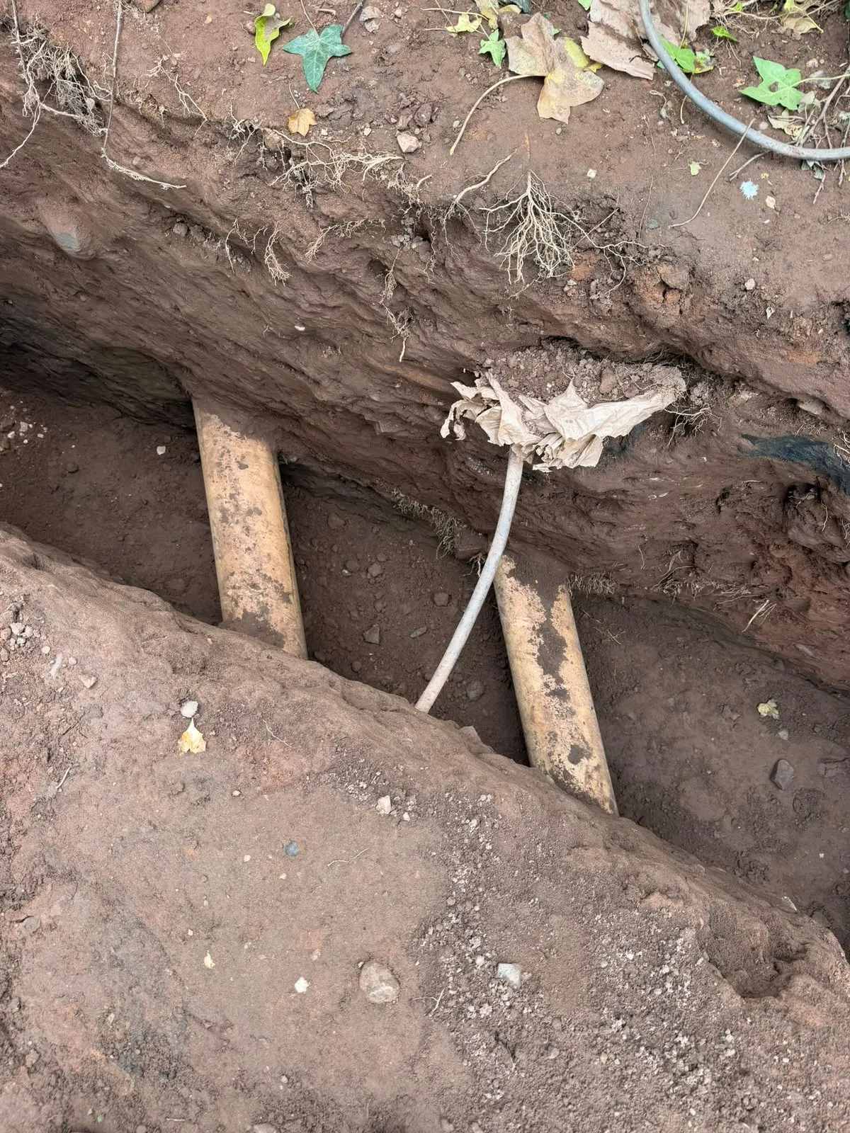 Drain runs exposed in the trench after clearing