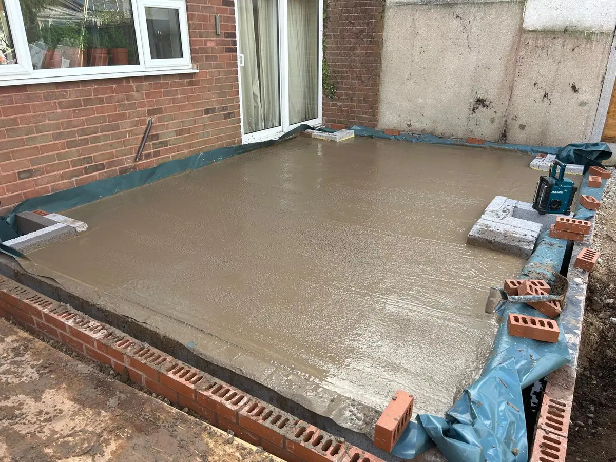 Poured concrete floor slab over damp proof membrane inside new brick footings