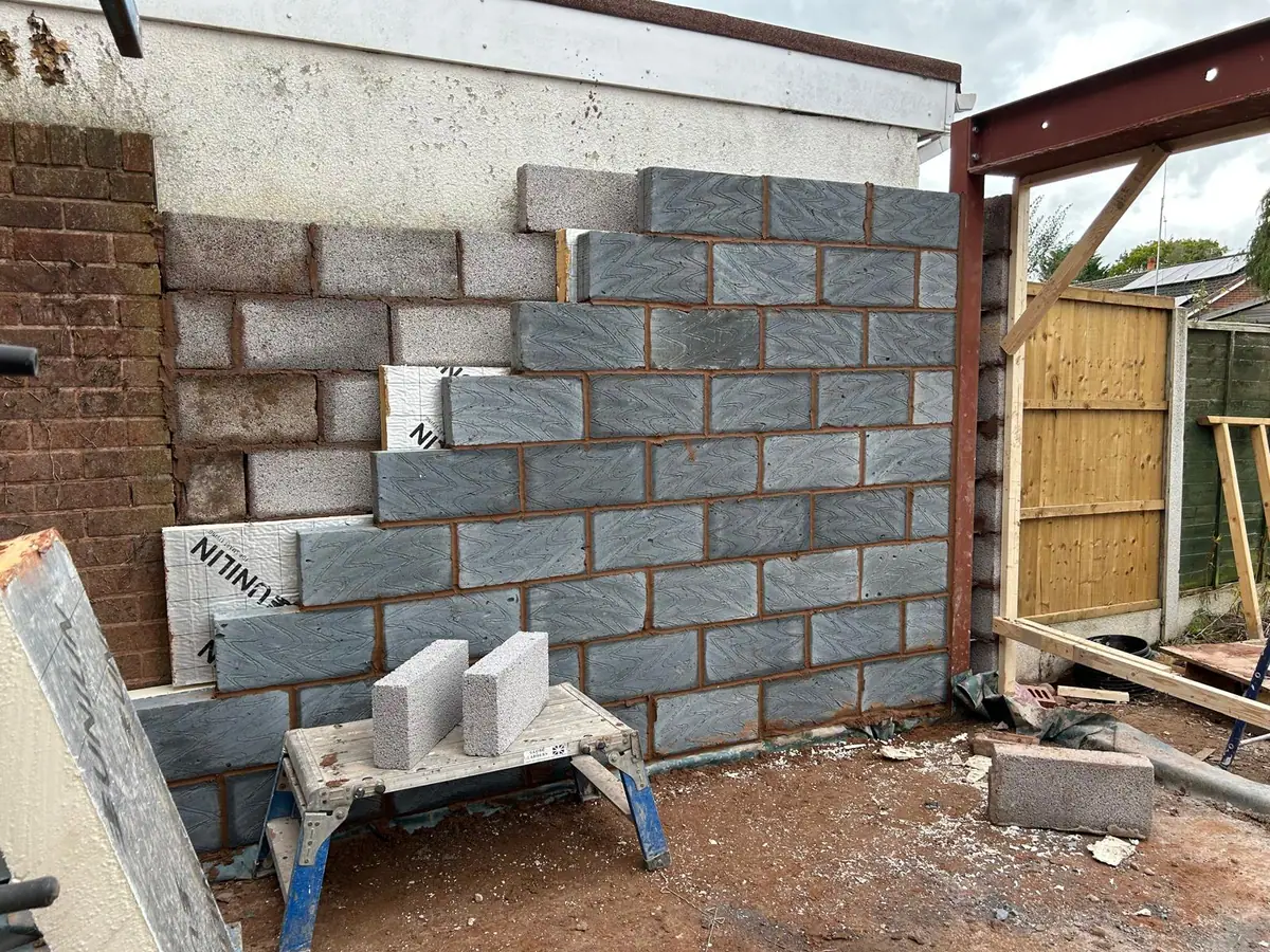 Insulated blockwork wall built up against the neighbouring boundary wall