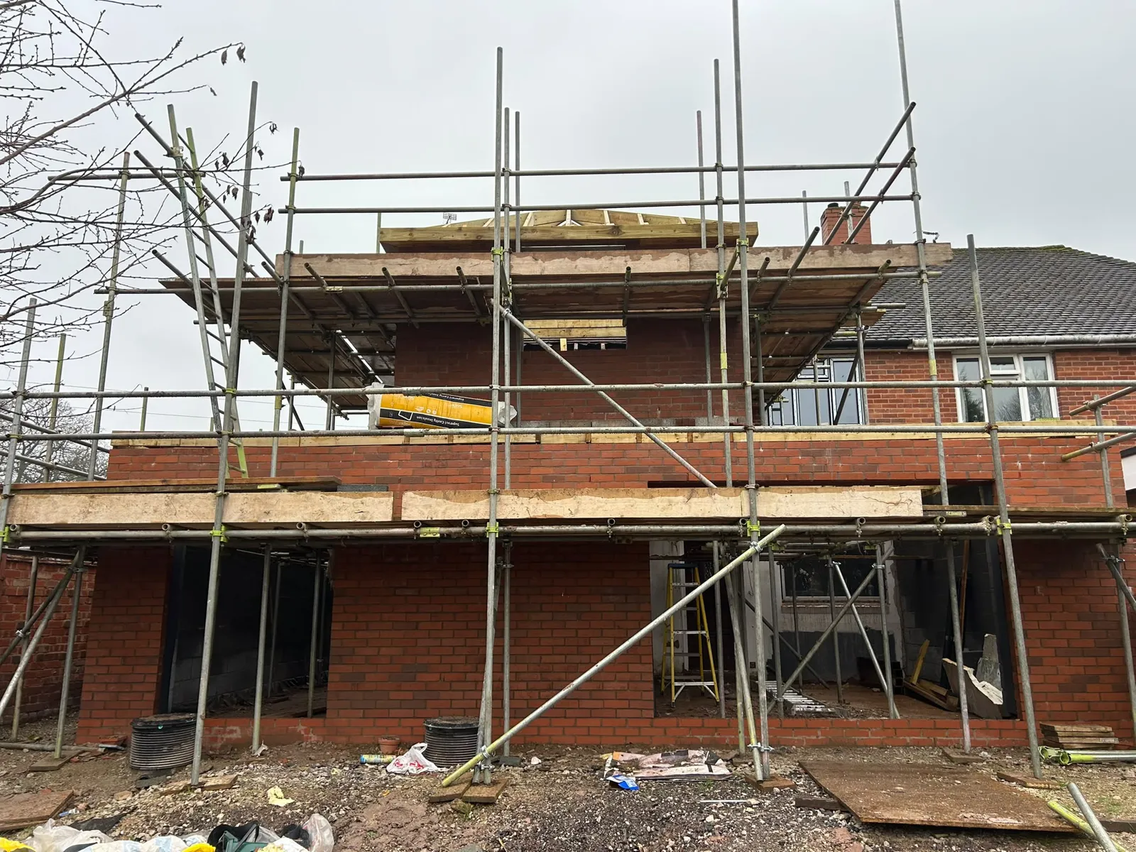 The scaffolded upper storey with window openings formed