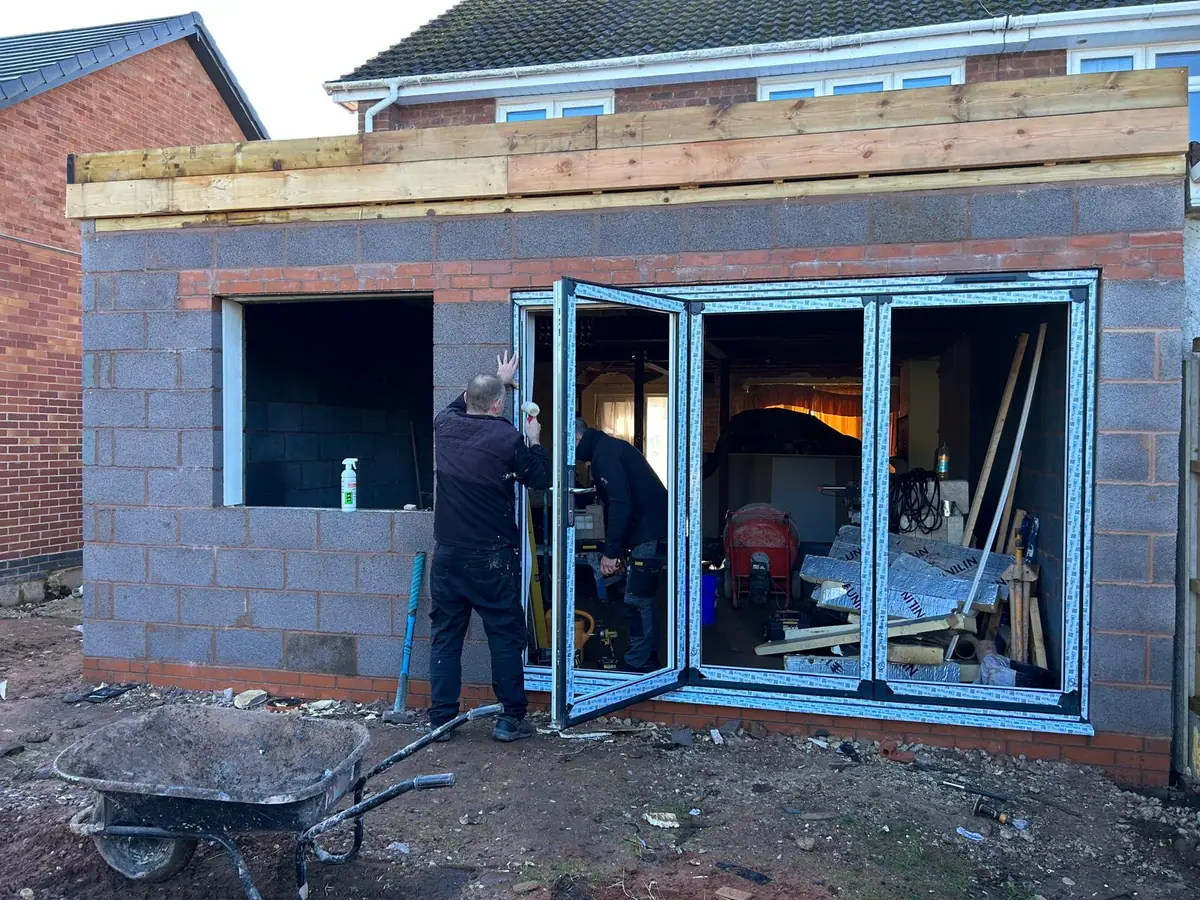 Aluminium bi-folding doors being installed into a new single storey extension