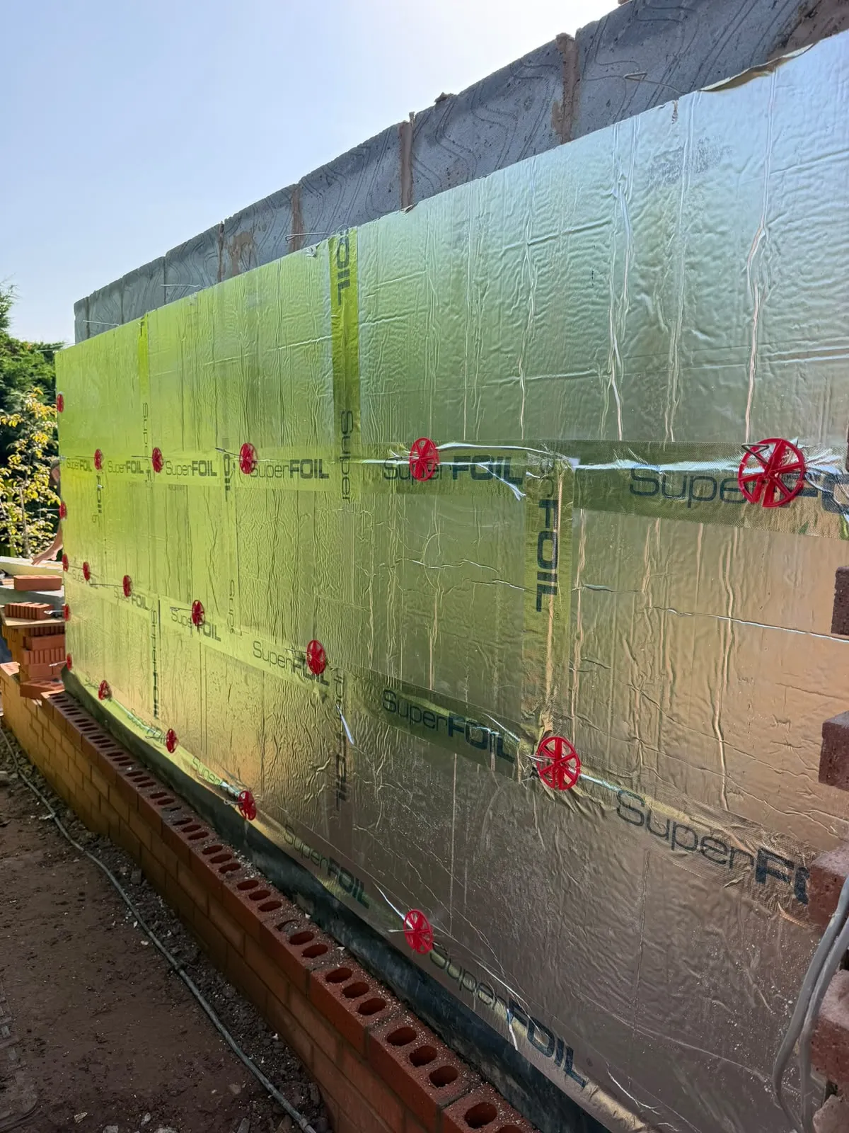 Foil-faced PIR insulation fixed across the orangery wall
