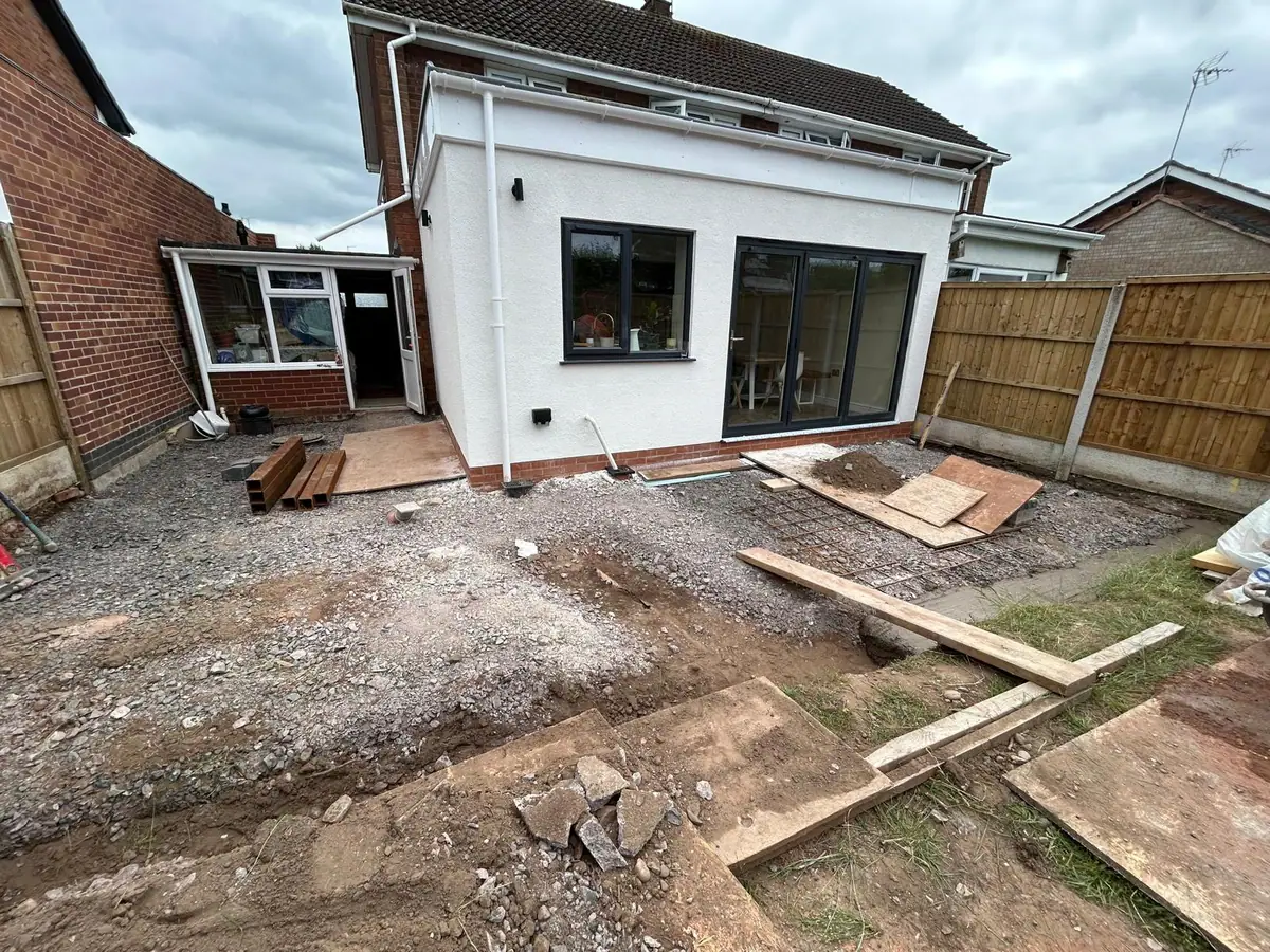 Completed single storey extension finished in white monocouche render with anthracite bi-folding doors