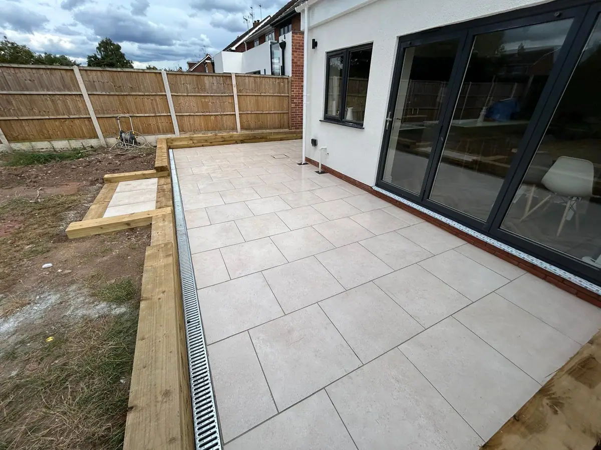 New porcelain patio and timber sleeper retaining wall outside a Wombourne extension