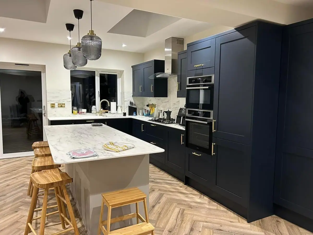 Finished navy shaker kitchen with marble worktops and brass fittings in a Wombourne extension