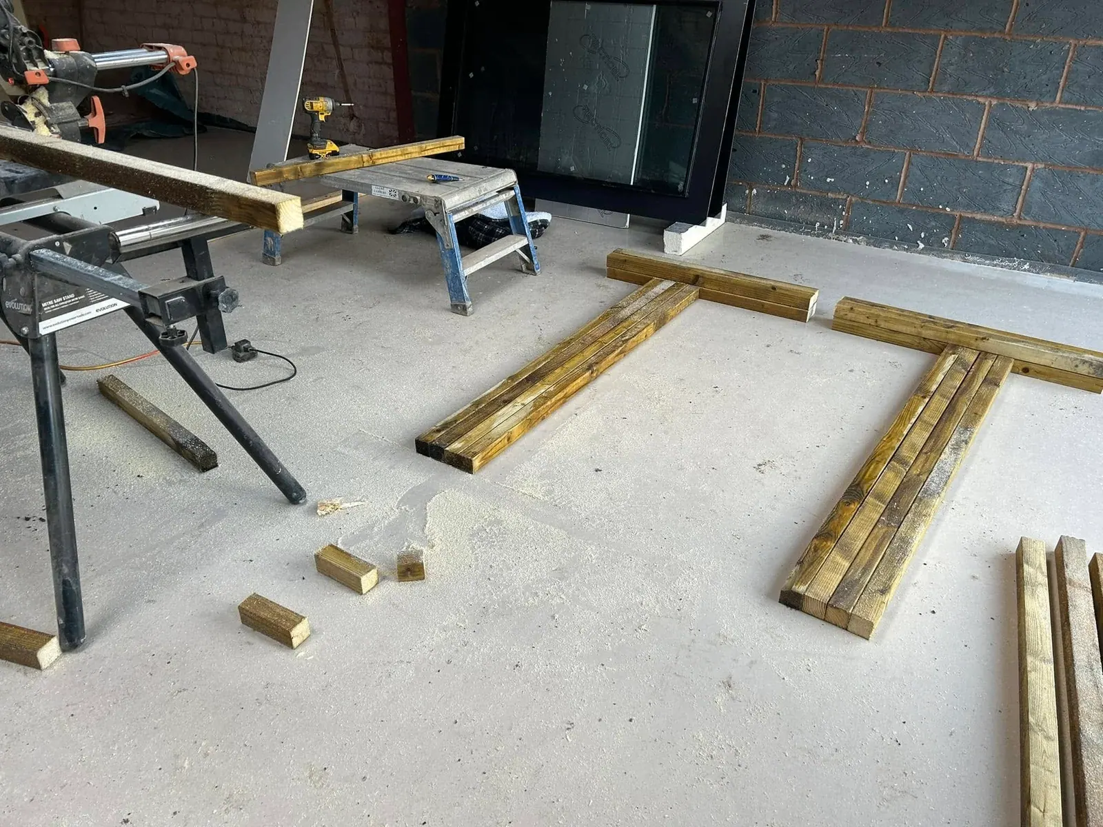 Timber battens cut and laid out on the floor of an extension under construction